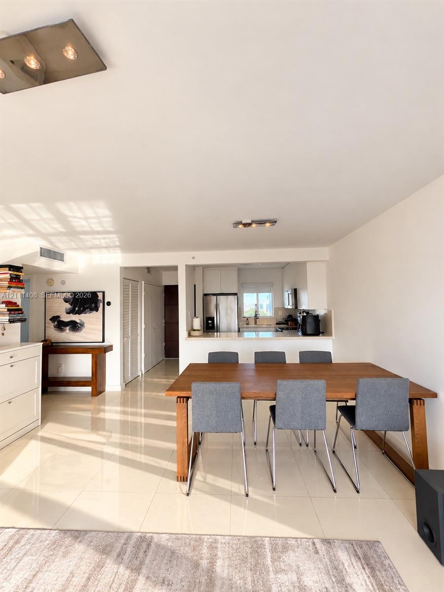 Floor-to-ceiling glass walls, polished tile flooring, balcony access, and minimalist overhead lighting