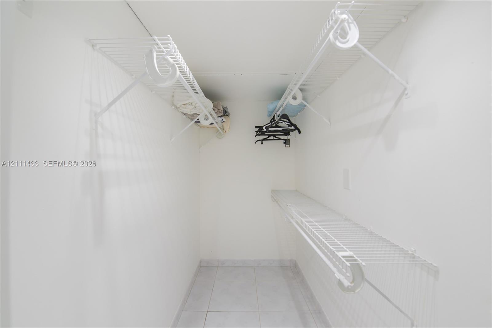 Storage space featuring white wire shelving and tile flooring