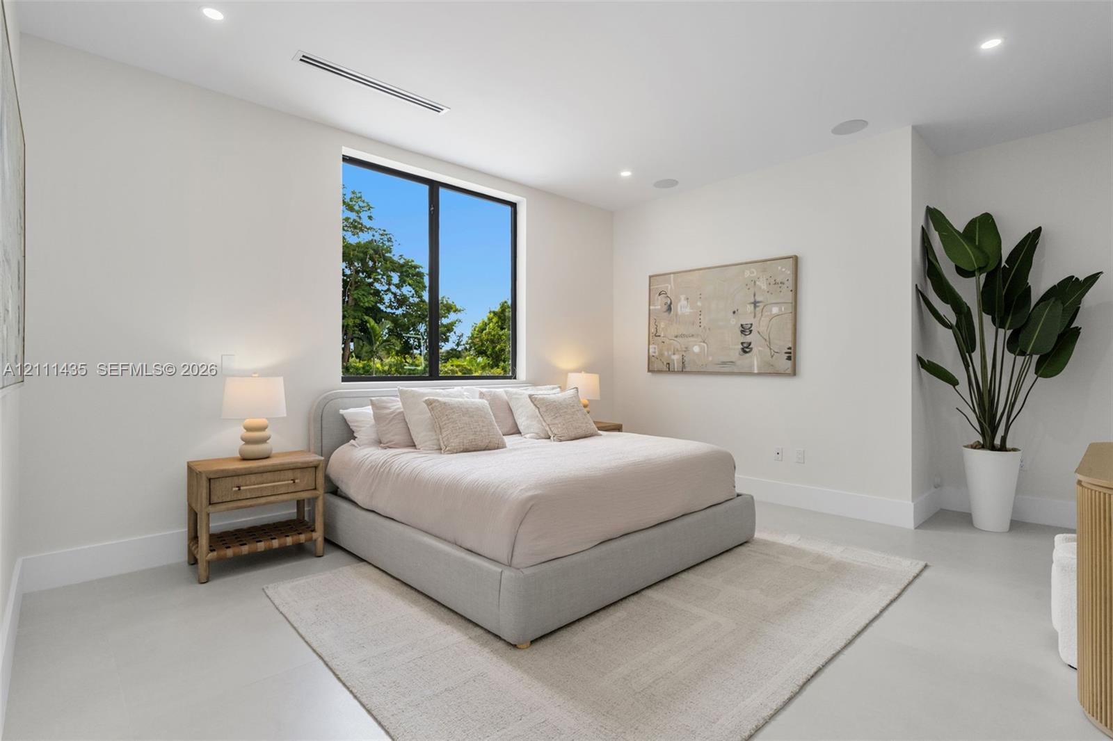 Neutral interior featuring high ceilings with recessed lighting, large window with black frame, and polished concrete flooring