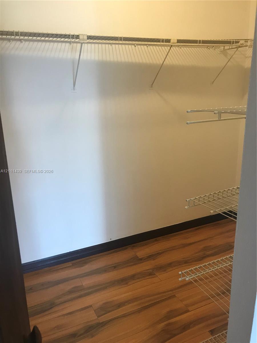 Storage space featuring wood-finish flooring and multi-level wire shelving