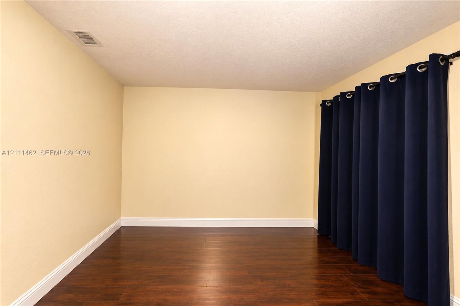 Room featuring wood-finish flooring and neutral wall color