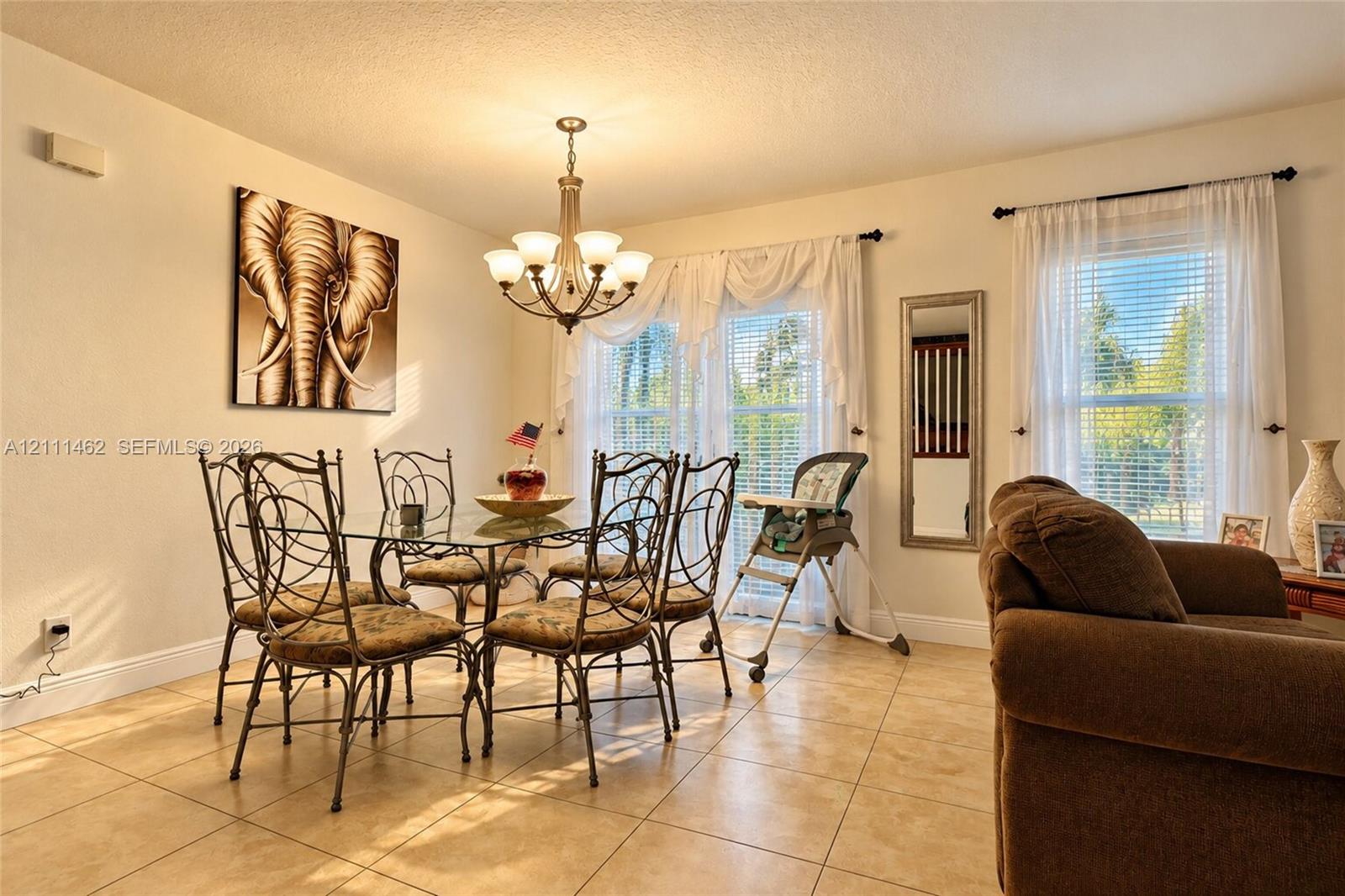 Ceramic tile flooring, classic multi-arm chandelier, and dual windows with horizontal blinds Ceramic tile flooring, classic multi-arm chandelier, and dual windows with horizontal blinds