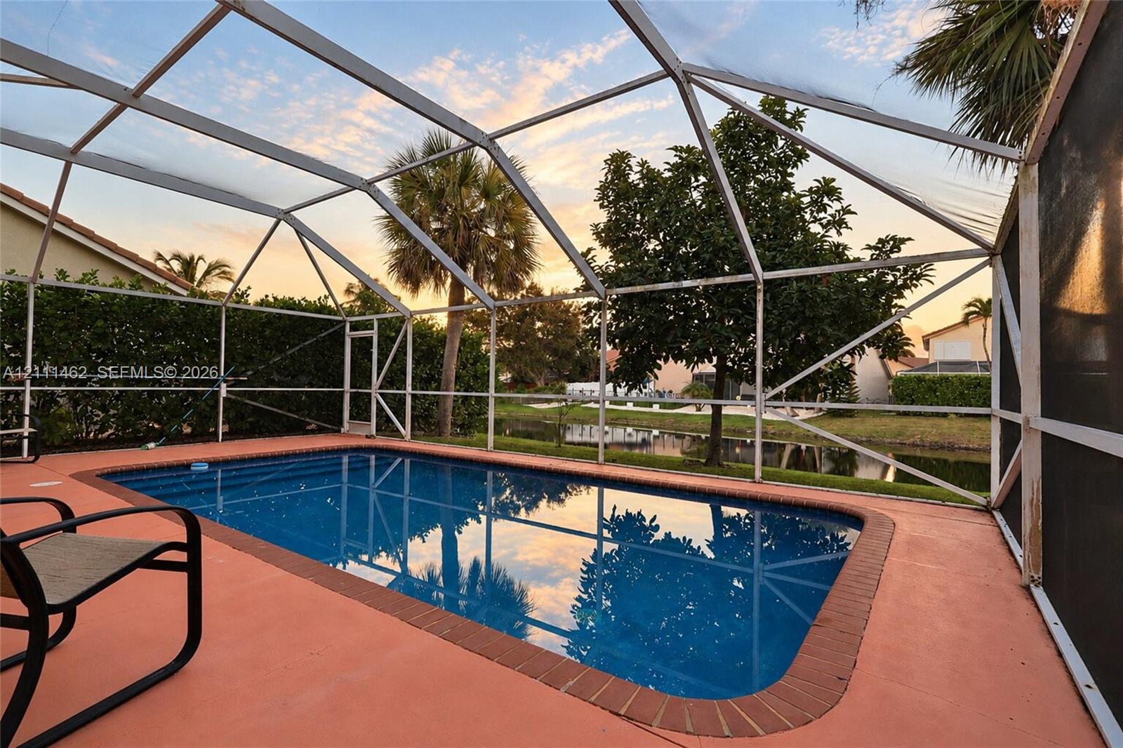 Screened-in pool enclosure with a brick-paver border and concrete deck Screened-in pool enclosure with a brick-paver border and concrete deck