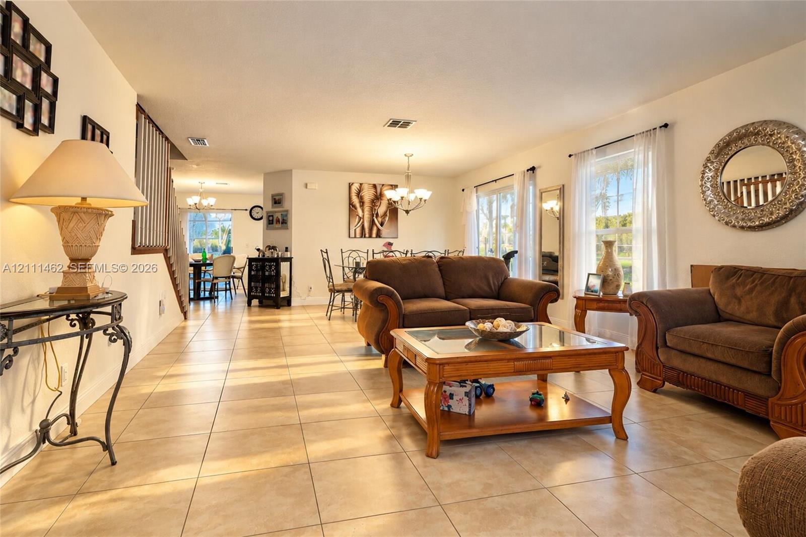 Neutral-toned tile flooring, recessed lighting, multi-arm chandelier, and open-plan layout Neutral-toned tile flooring, recessed lighting, multi-arm chandelier, and open-plan layout