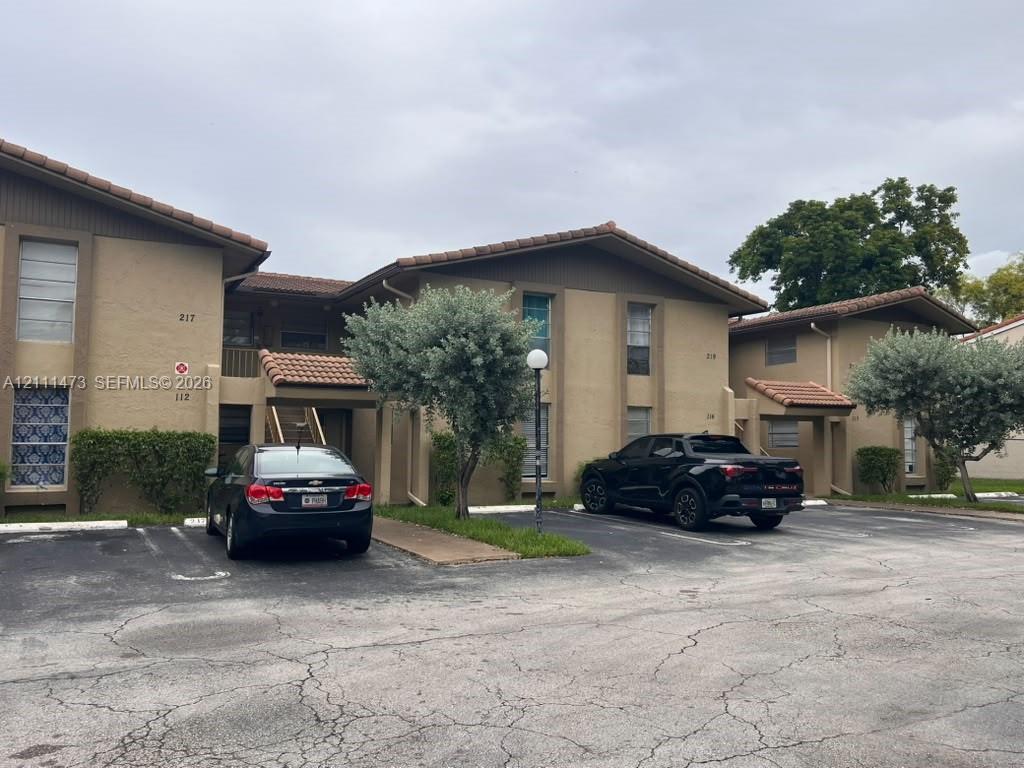 Multi-level stucco exterior with a tile roof and dedicated surface parking Multi-level stucco exterior with a tile roof and dedicated surface parking