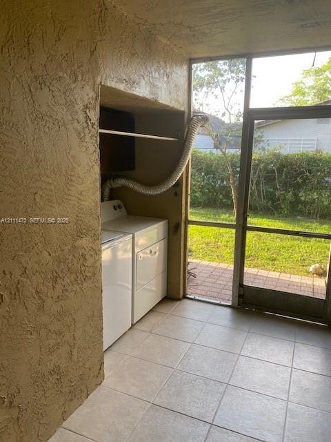 Screened-in enclosure with tile flooring and a dedicated laundry area featuring built-in shelving and exterior access