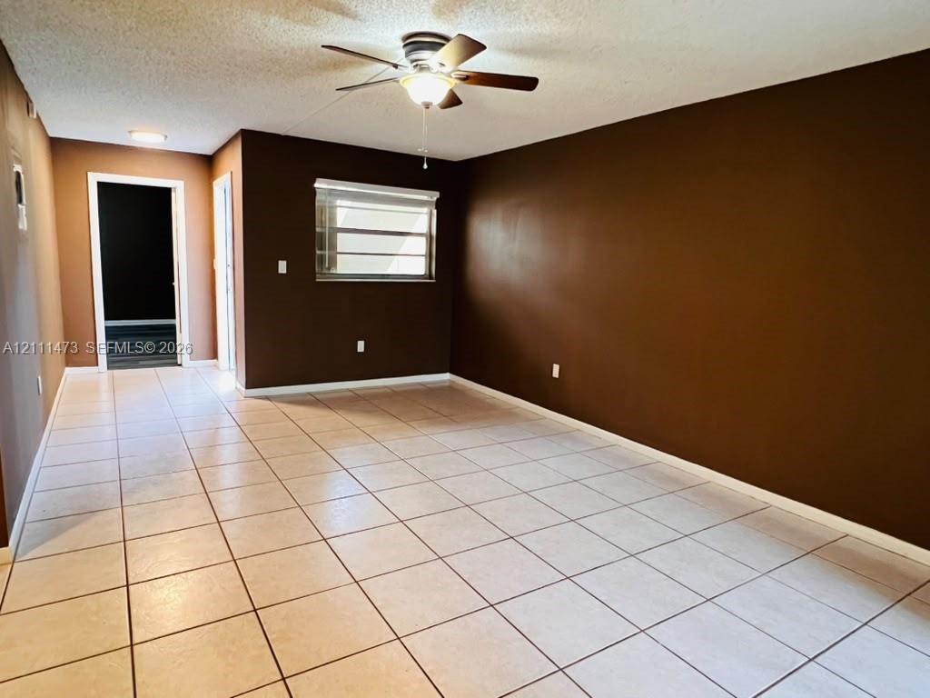 Neutral ceramic tile flooring, ceiling fan with integrated lighting, and horizontal window blinds Neutral ceramic tile flooring, ceiling fan with integrated lighting, and horizontal window blinds