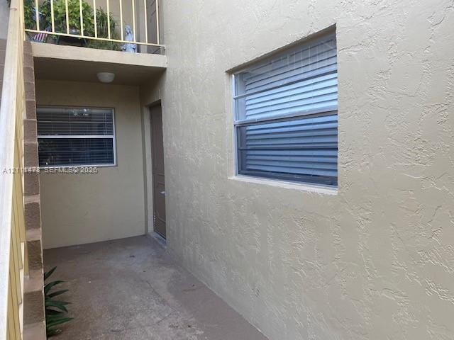 Stucco exterior finish with integrated stairwell, metal railing, and aluminum-frame windows