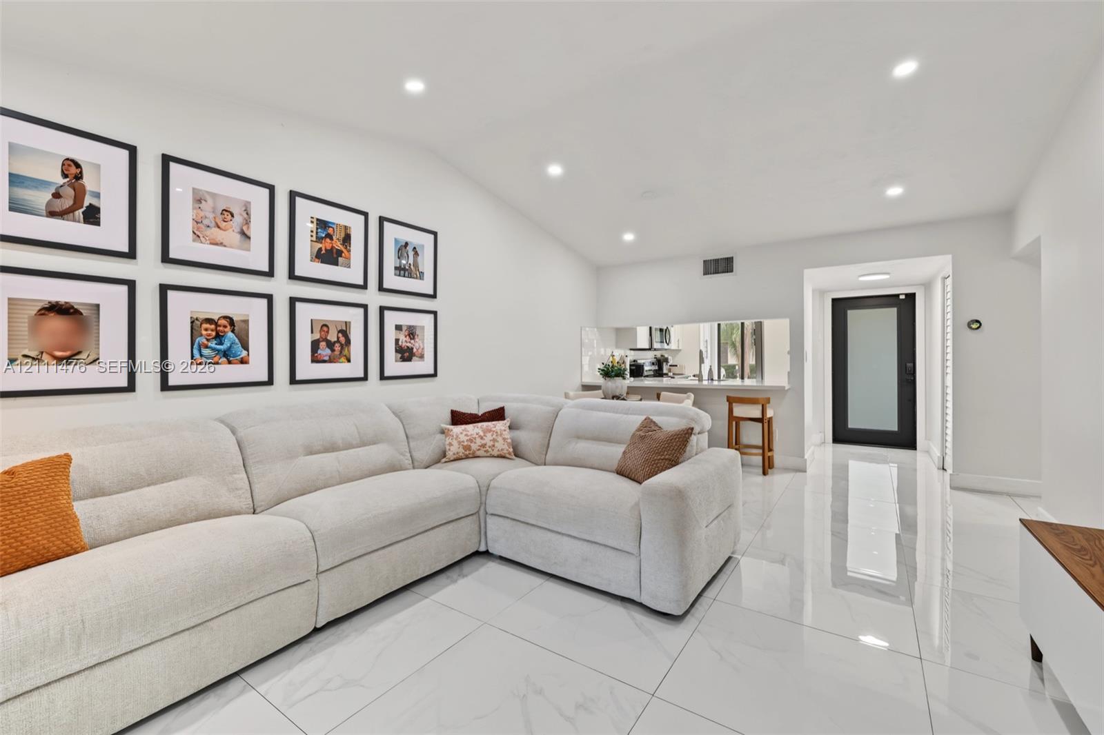 Large-format tile flooring, recessed lighting, and an exterior door featuring a frosted glass panel