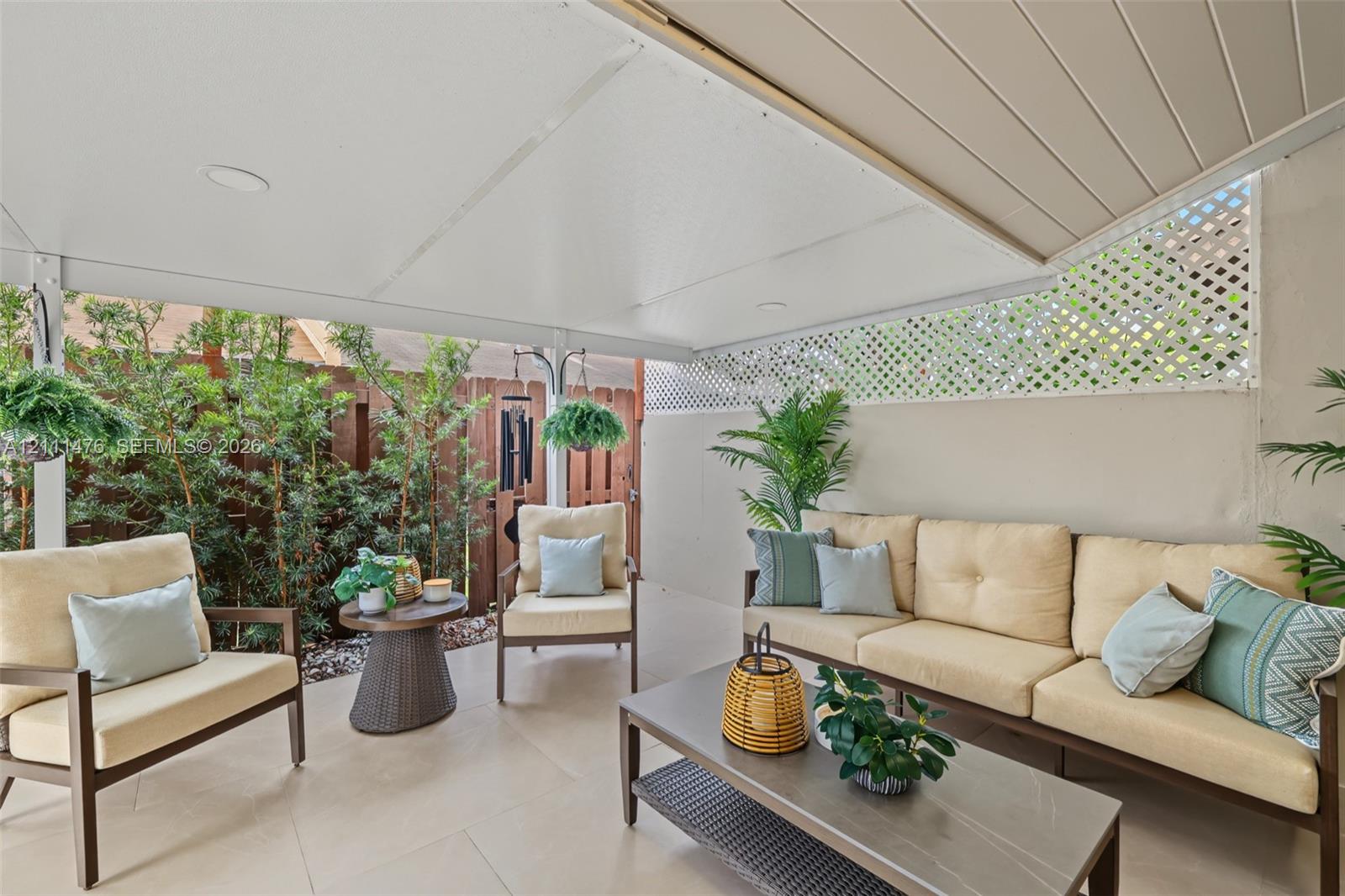 Covered patio featuring large-format tile flooring, recessed lighting, and a white lattice privacy screen