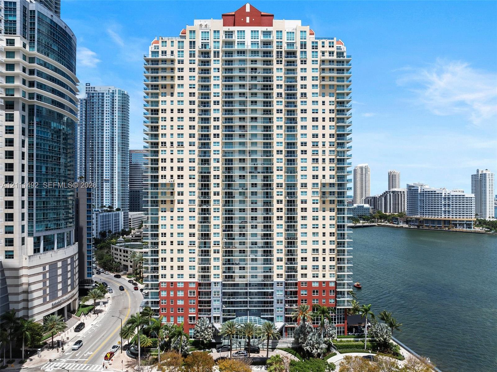 High-rise building featuring a glass-enclosed entrance, wraparound private balconies, expansive window glass, and exterior brick accents High-rise building featuring a glass-enclosed entrance, wraparound private balconies, expansive window glass, and exterior brick accents