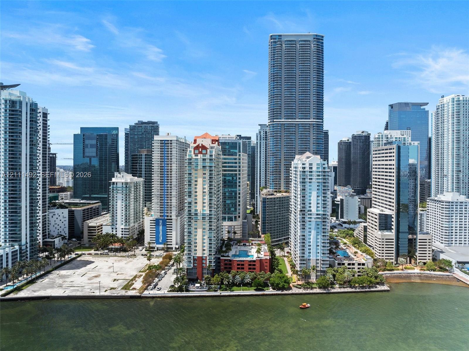 Aerial perspective of the metropolitan skyline featuring high-rise concrete and glass structures, prominent coastal positioning, and established urban infrastructure