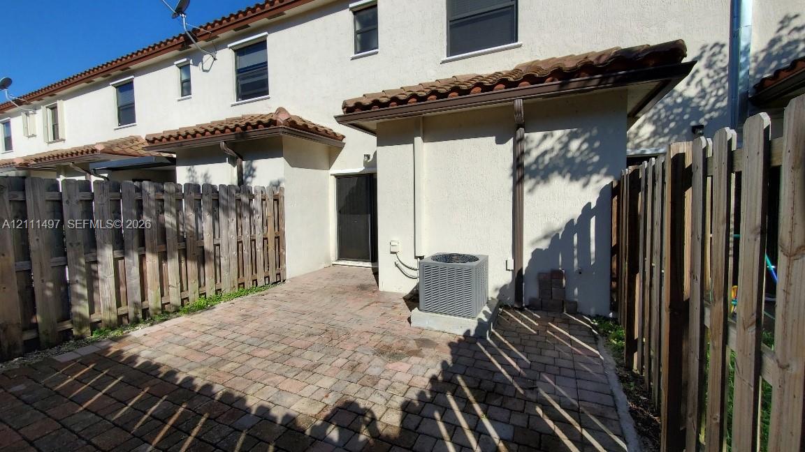 Private rear patio featuring paver flooring and wood-style privacy fencing