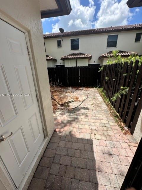 Private outdoor patio featuring concrete paver flooring and wood privacy fencing