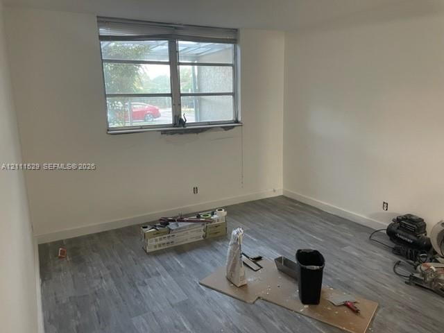 Room featuring wood-finish flooring and a multi-pane horizontal window