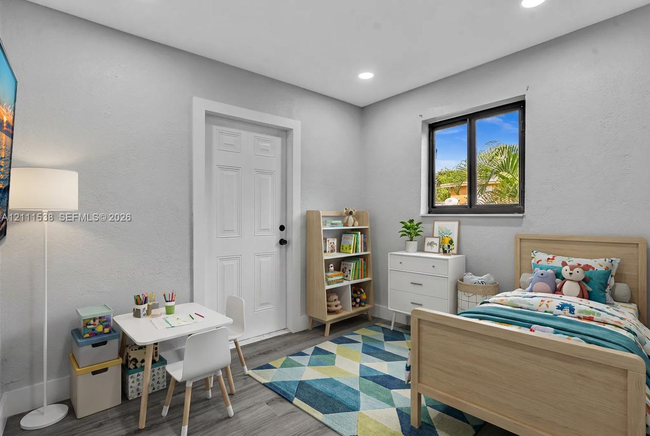 Interior space featuring neutral wall paint, wood-finish flooring, recessed lighting, and a single-pane sliding window