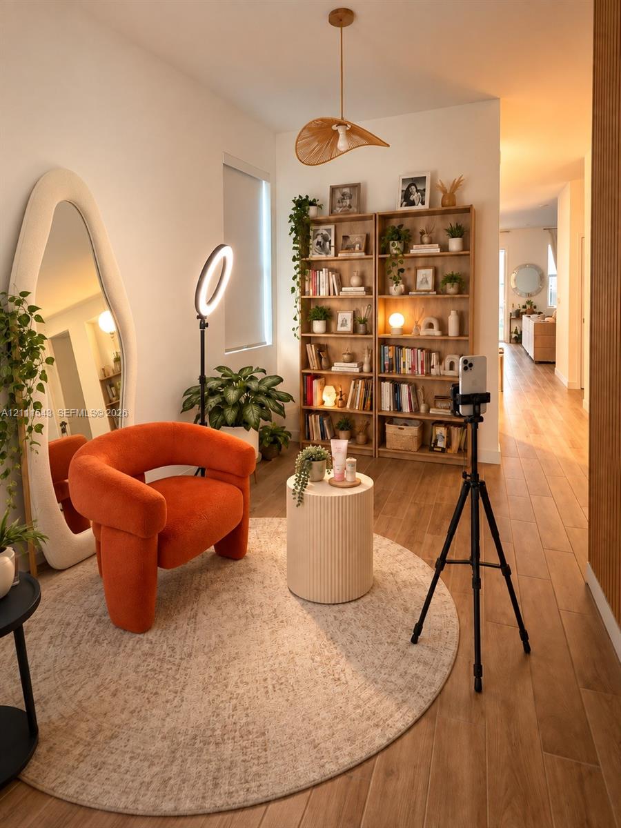 Wood-finish flooring, built-in floor-to-ceiling wooden shelving, and a decorative pendant light fixture