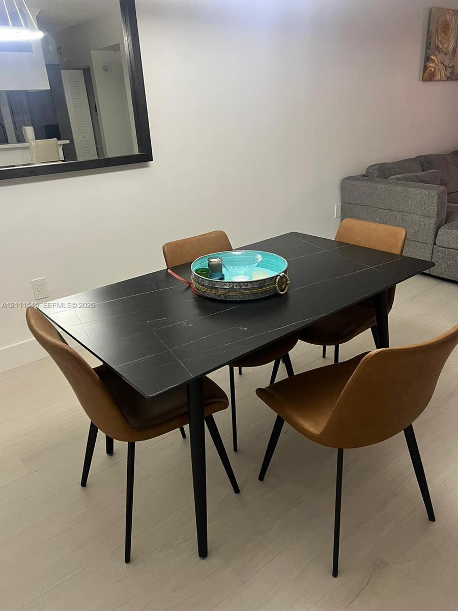 Large, rectangular wall-mounted mirror with a black frame and light-toned, wood-finish flooring Large, rectangular wall-mounted mirror with a black frame and light-toned, wood-finish flooring