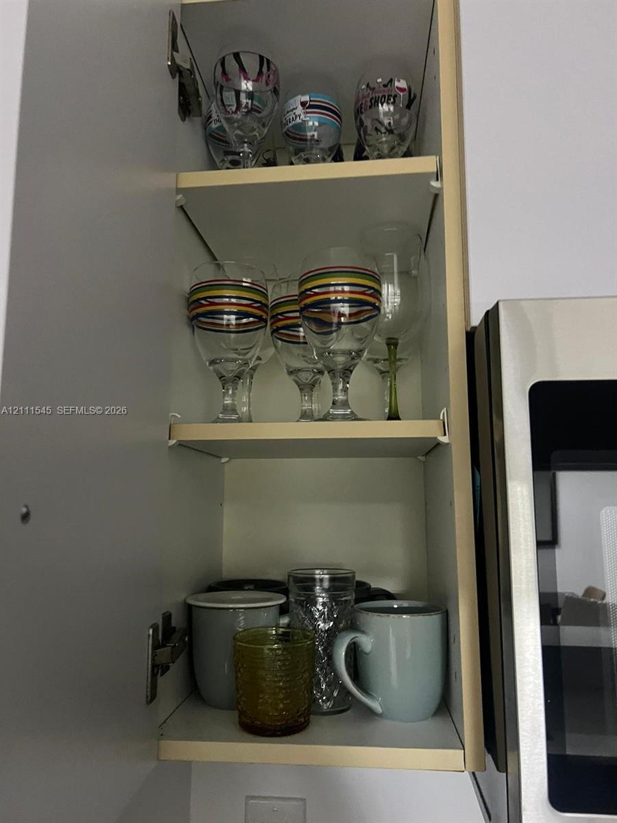 Wall-mounted upper cabinet featuring light-finish cabinetry, adjustable shelving, and internal hinges Wall-mounted upper cabinet featuring light-finish cabinetry, adjustable shelving, and internal hinges