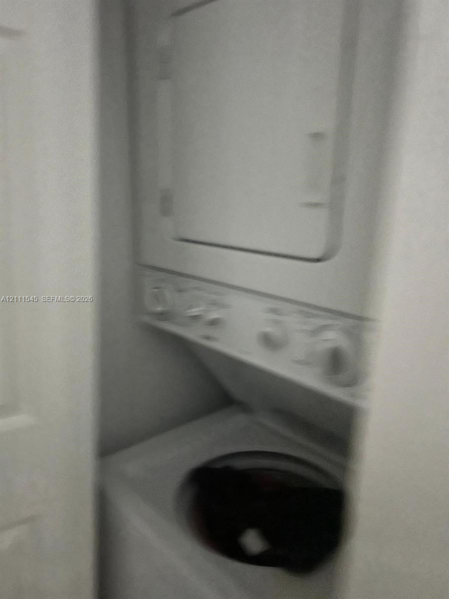 Stacked laundry unit featuring a top-loading washer and front-loading dryer with integrated control dials Stacked laundry unit featuring a top-loading washer and front-loading dryer with integrated control dials