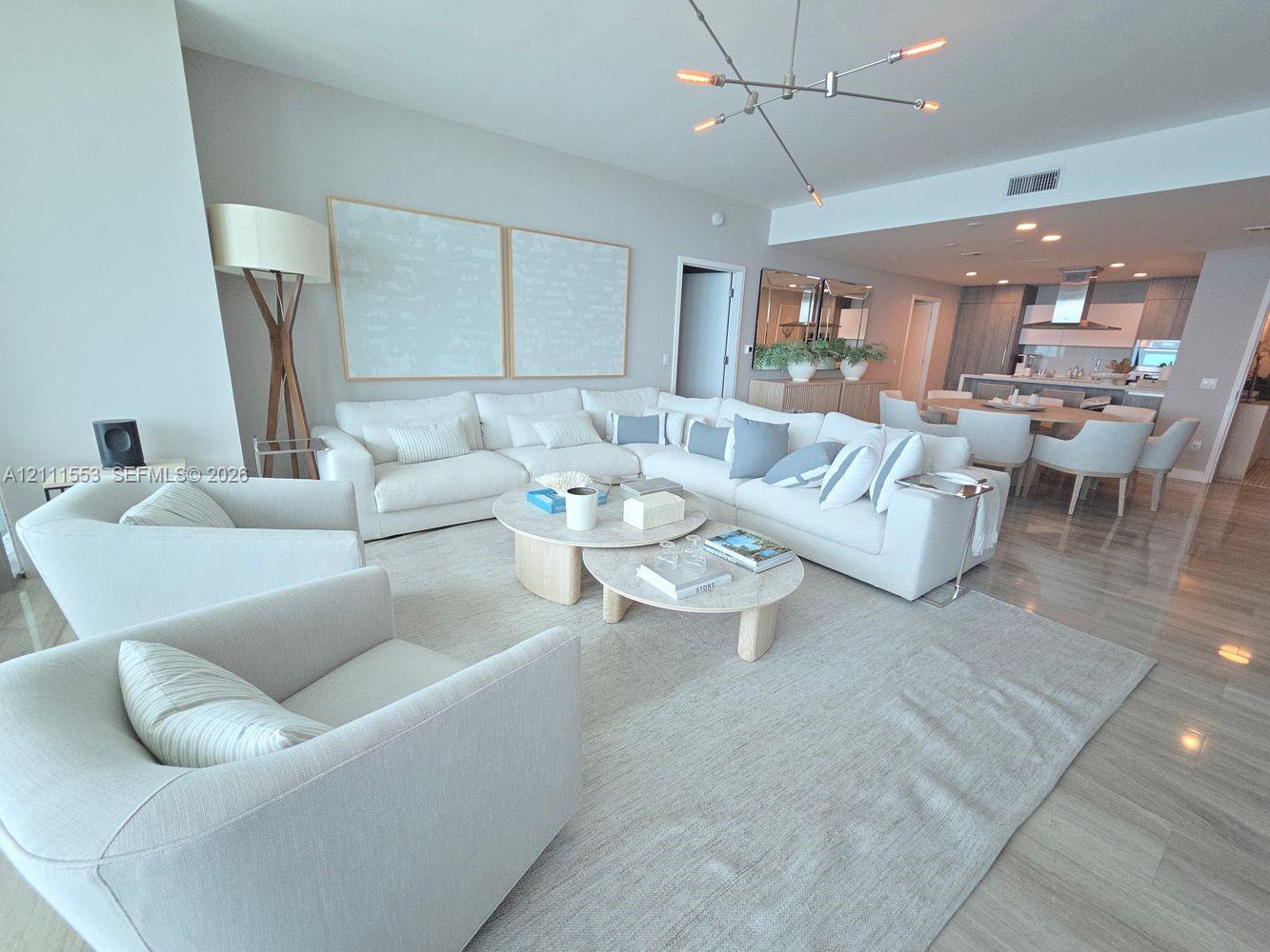 Open-concept space featuring wood-finish flooring, recessed lighting, and a modern multi-arm chandelier