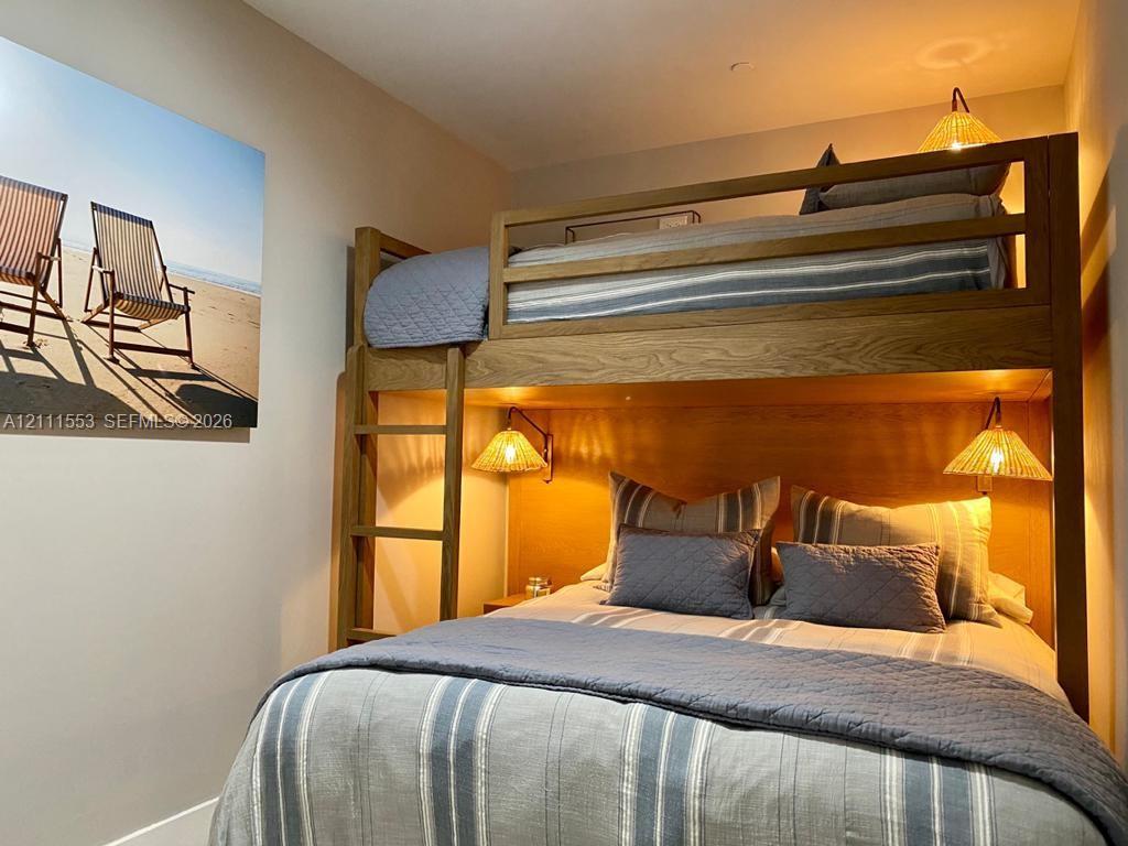 Custom-built wooden bunk structure with an integrated ladder and wall-mounted light fixtures
