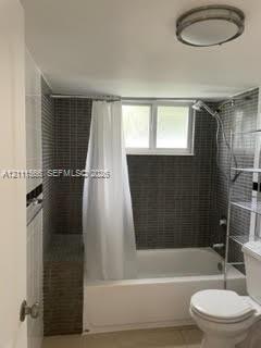 Full-height mosaic tile shower surround, integrated tile bench, recessed window, and ceiling-mounted dome lighting Full-height mosaic tile shower surround, integrated tile bench, recessed window, and ceiling-mounted dome lighting