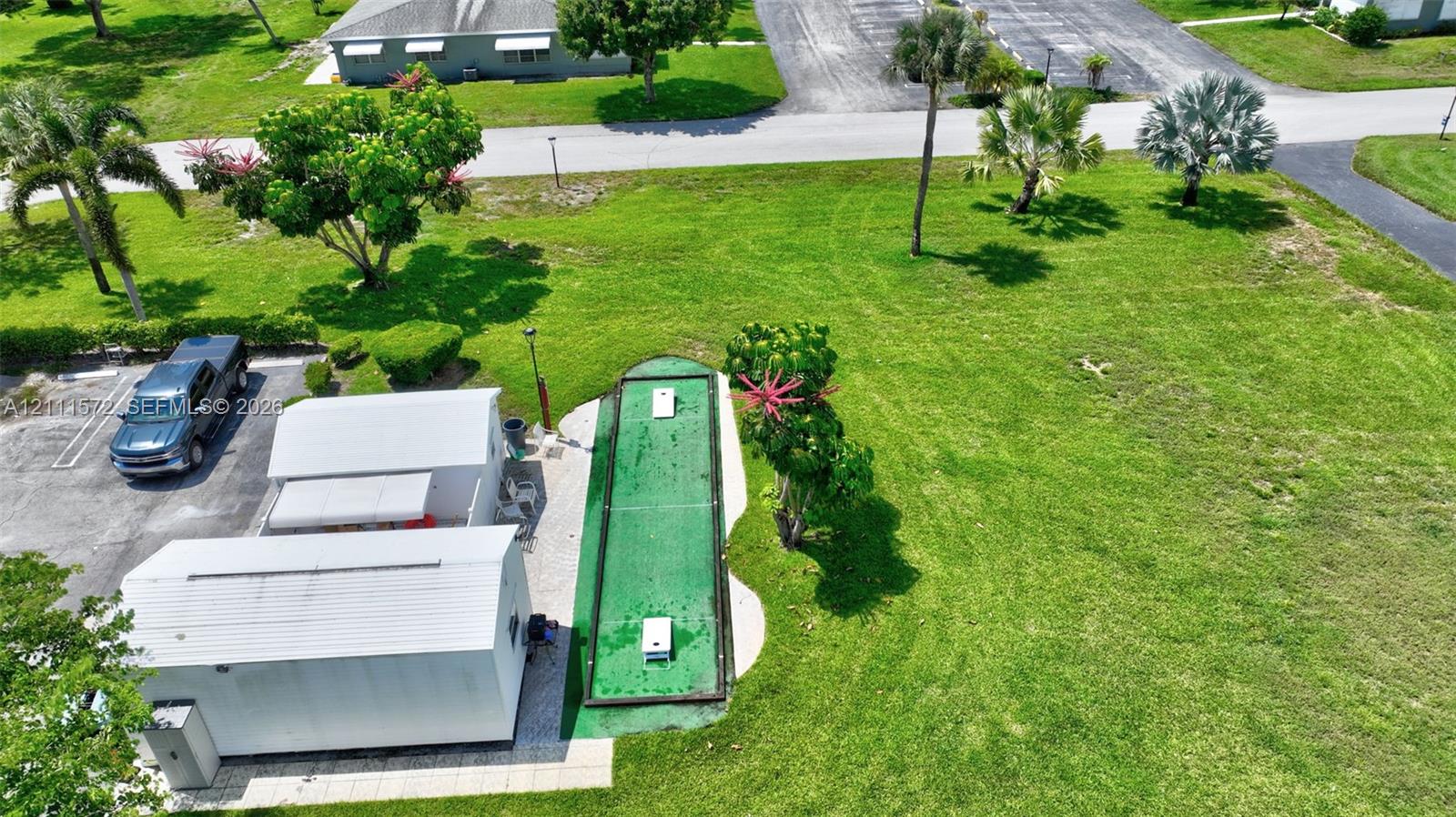 Recreational complex featuring a clubhouse, heated swimming pool with concrete decking, shuffleboard & bocce ball courts