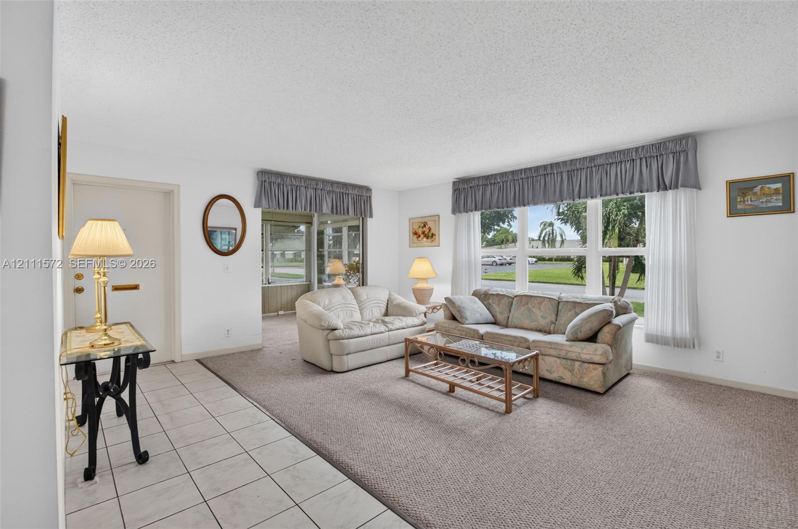 Neutral-toned ceramic tile flooring at entry, plush berber carpeting, and expansive multi-pane windows providing lots of natural light