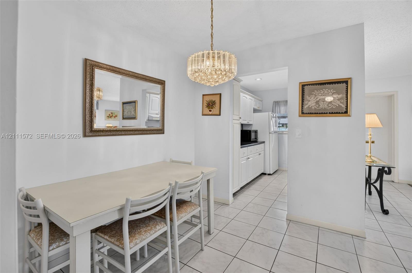 Dining area featuring tile flooring and a crystal-accented chandelier