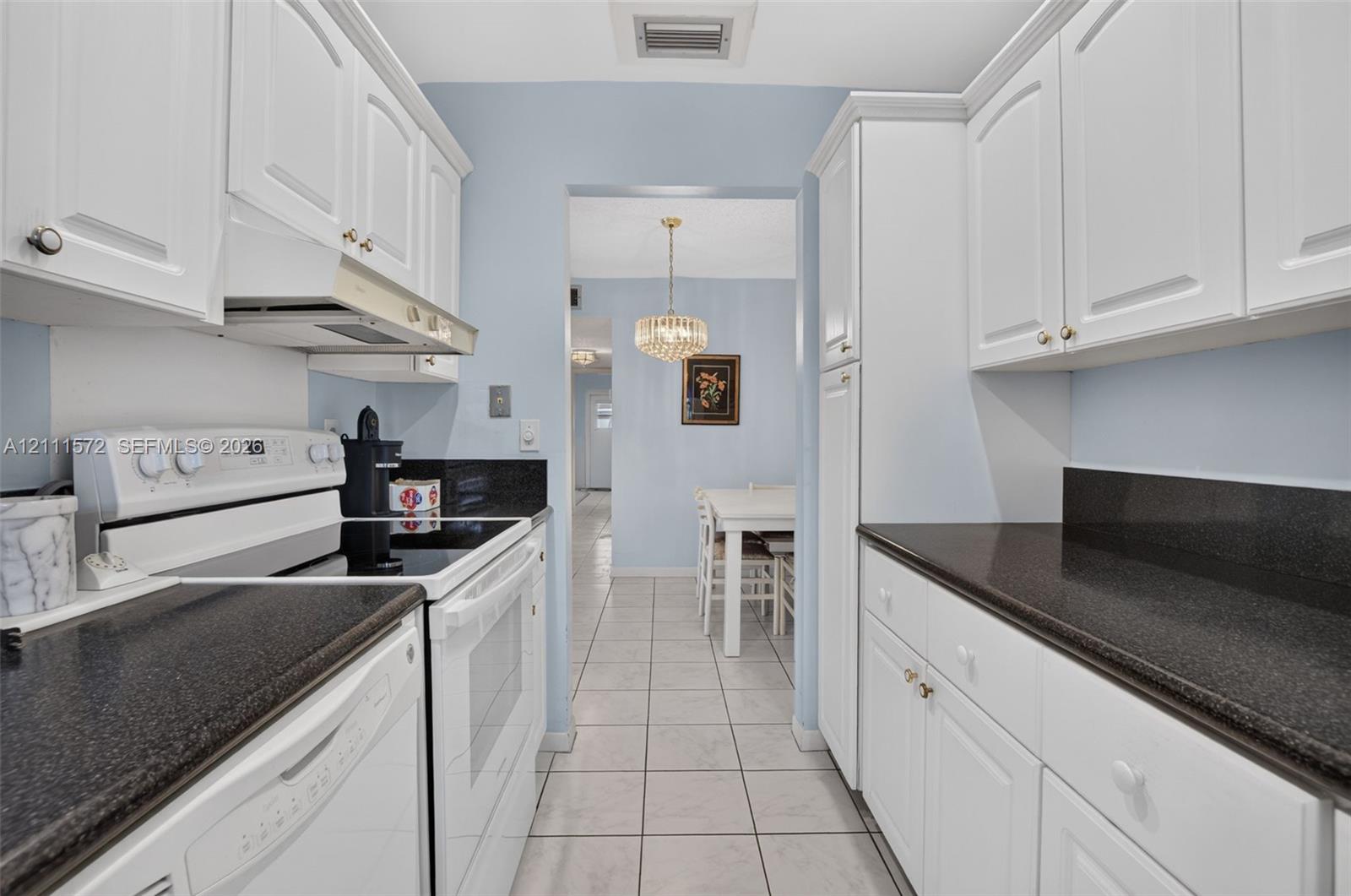 Kitchen featuring white cabinetry, stone countertops, tile flooring, and recessed lighting