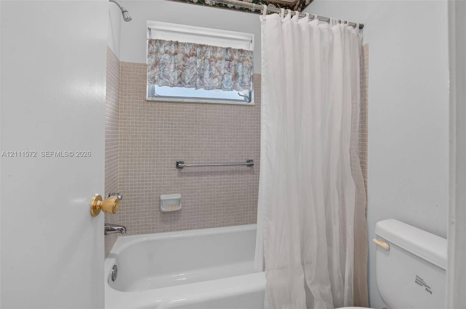 Bathroom featuring a bathtub with a tiled surround, integrated soap dish