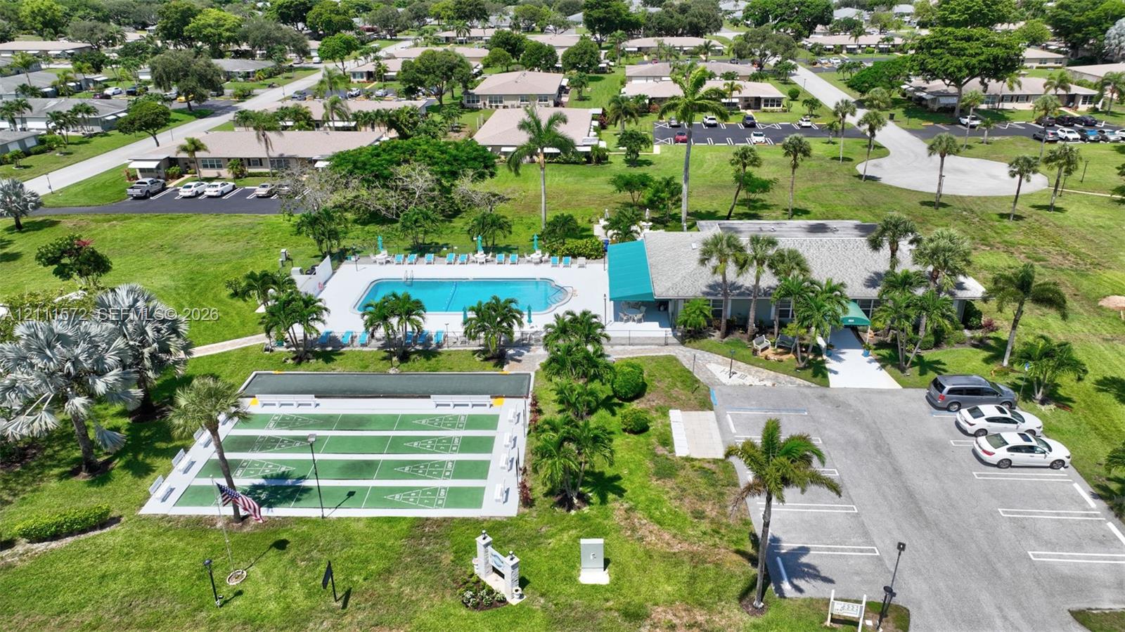 Recreational complex featuring a clubhouse, heated swimming pool with concrete decking, shuffleboard & bocce ball courts