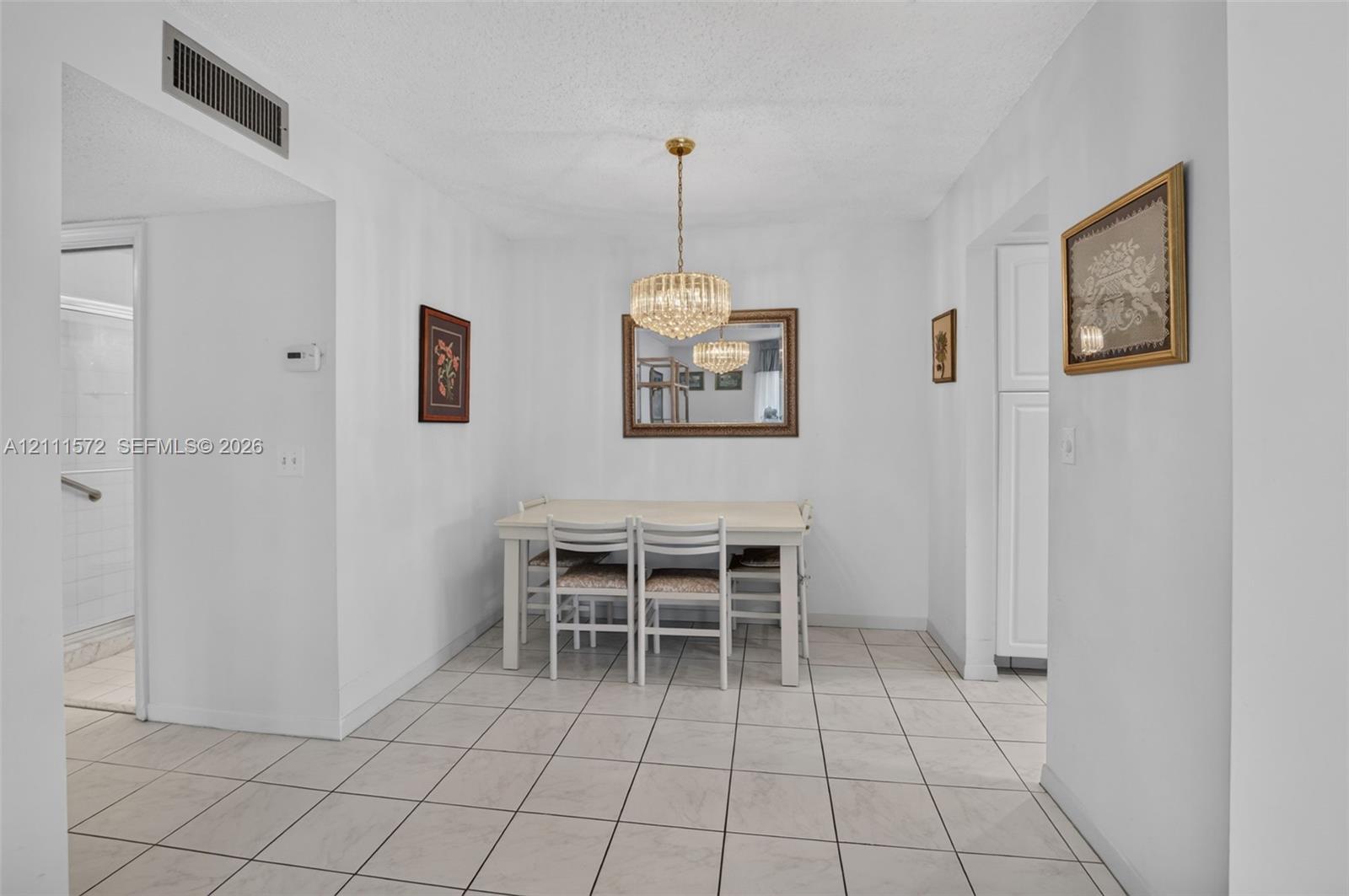 Dining area featuring, ceramic tile flooring and a tiered crystal chandelier