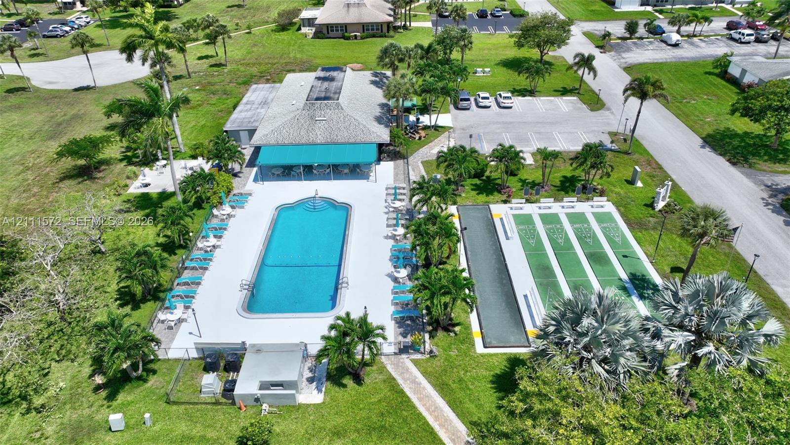 Recreational complex featuring a clubhouse, heated swimming pool with concrete decking, shuffleboard & bocce ball courts