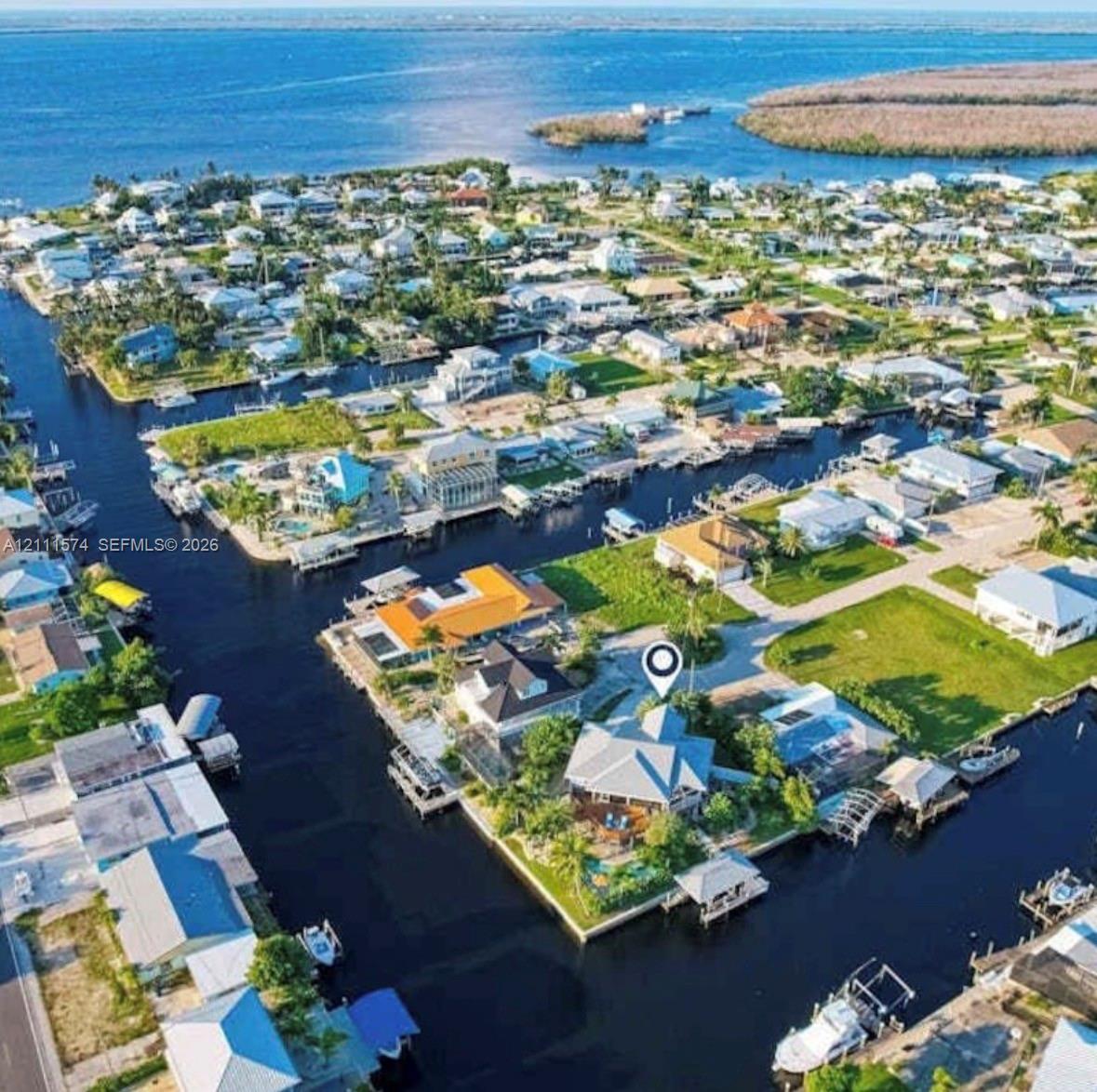 Waterfront property featuring deep-water canal access, private boat dock, multi-sided perimeter bulkhead, and mature landscaping