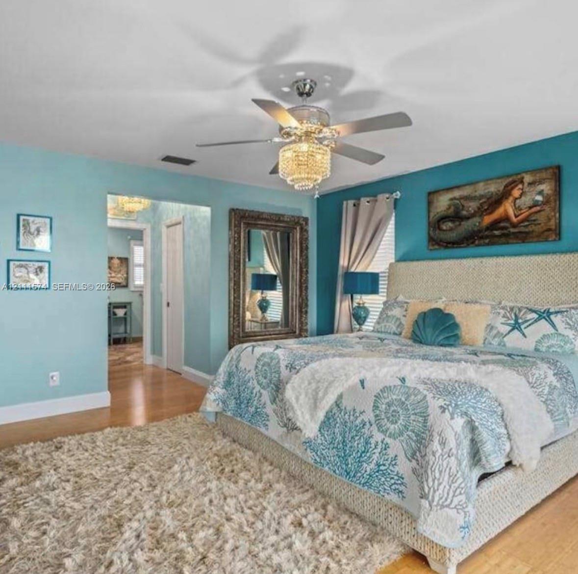 Wood-finish flooring, crystal-accented ceiling fan with integrated lighting, and neutral-toned wall treatments