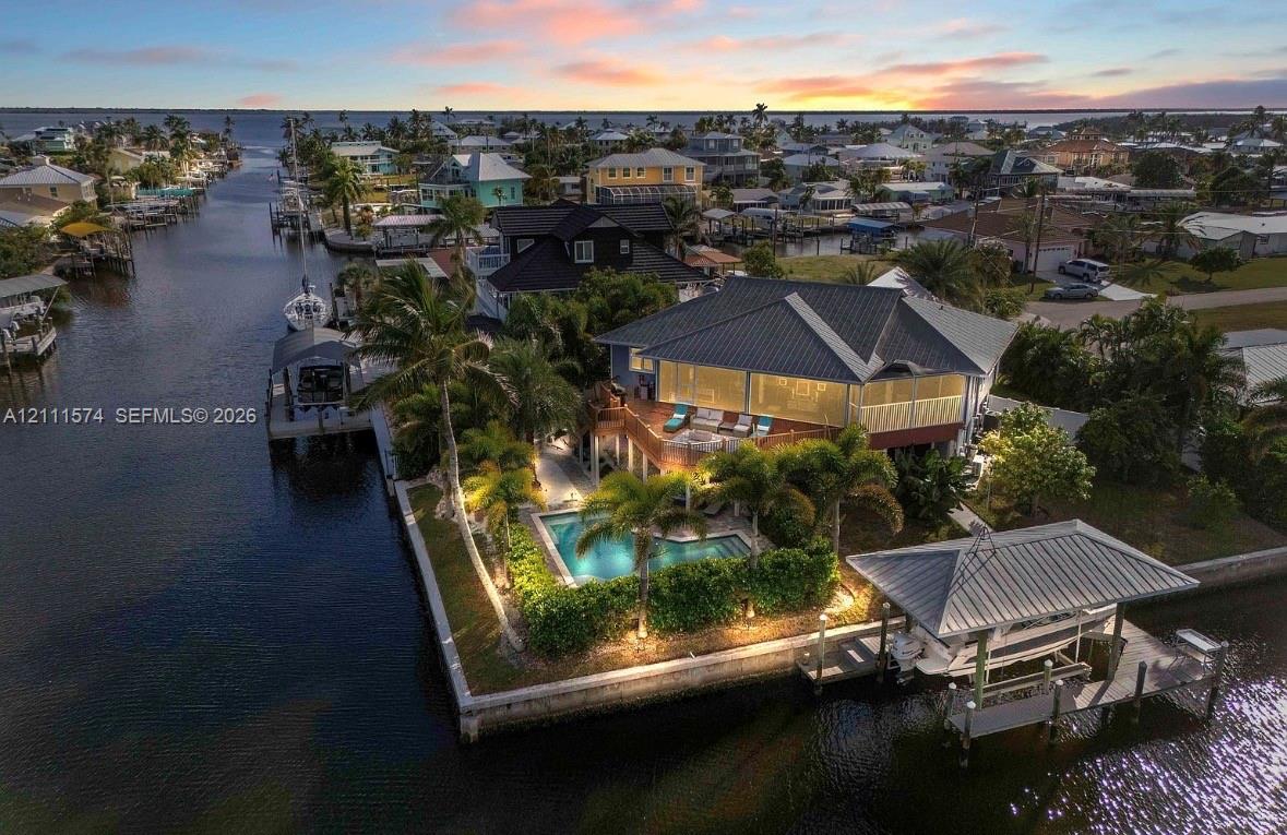 Waterfront property featuring a private swimming pool, multi-level exterior decking, and a dedicated boat dock
