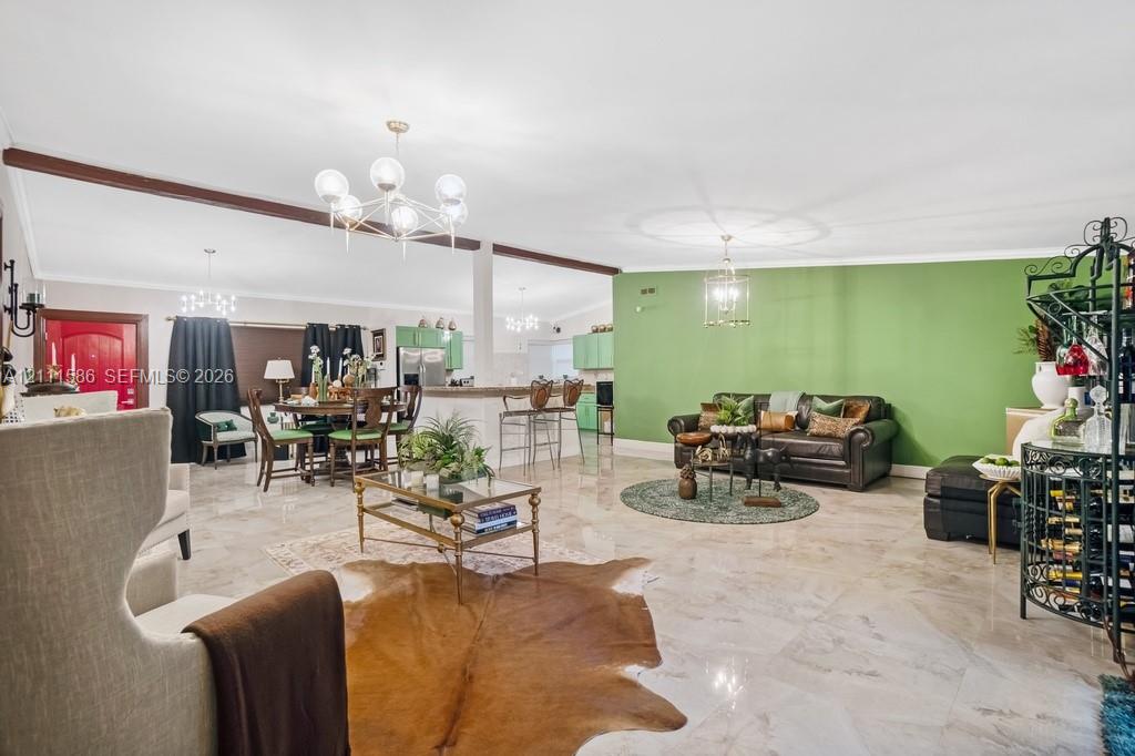 Open-concept interior featuring high ceilings with exposed wood beams, polished stone flooring, and multiple tiered glass chandeliers