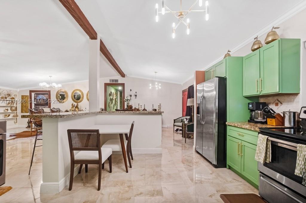 Kitchen featuring custom green cabinetry, stone countertops, stainless steel appliances, polished tile flooring, and modern multi-light chandeliers