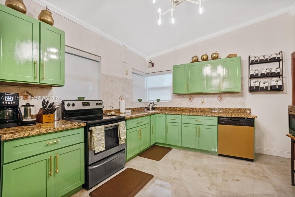 Kitchen featuring glossy green cabinetry with gold-tone hardware, stone-surface countertops, tile backsplash, and large-format tile flooring