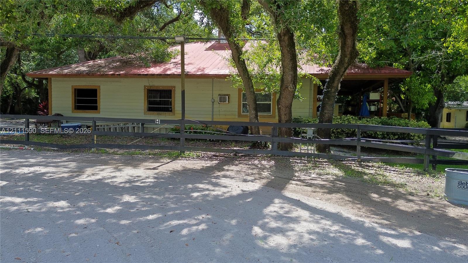 Exterior featuring horizontal siding, a metal roof, a covered porch, and a black split-rail fence