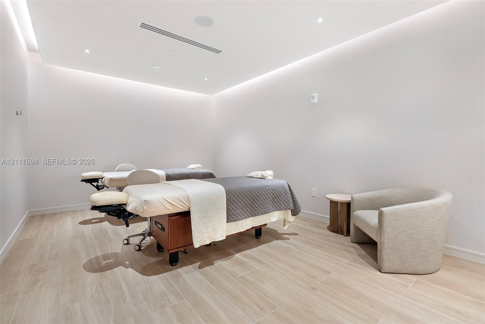 Neutral interior space featuring wood-finish flooring, recessed ceiling lighting, and perimeter cove lighting