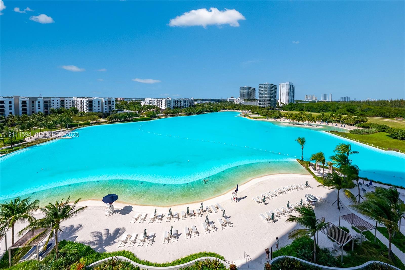 Expansive turquoise lagoon, white sand beach, and tropical landscaping