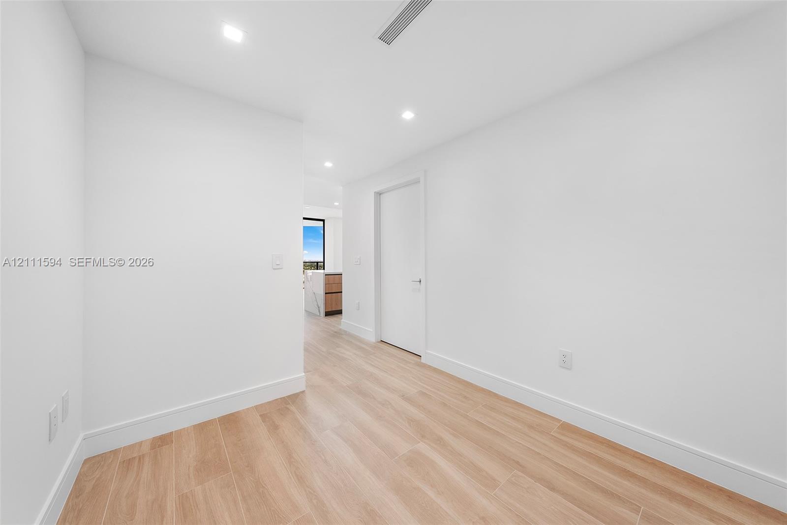 Interior space featuring wood-finish flooring, recessed lighting, and crisp white wall finishes