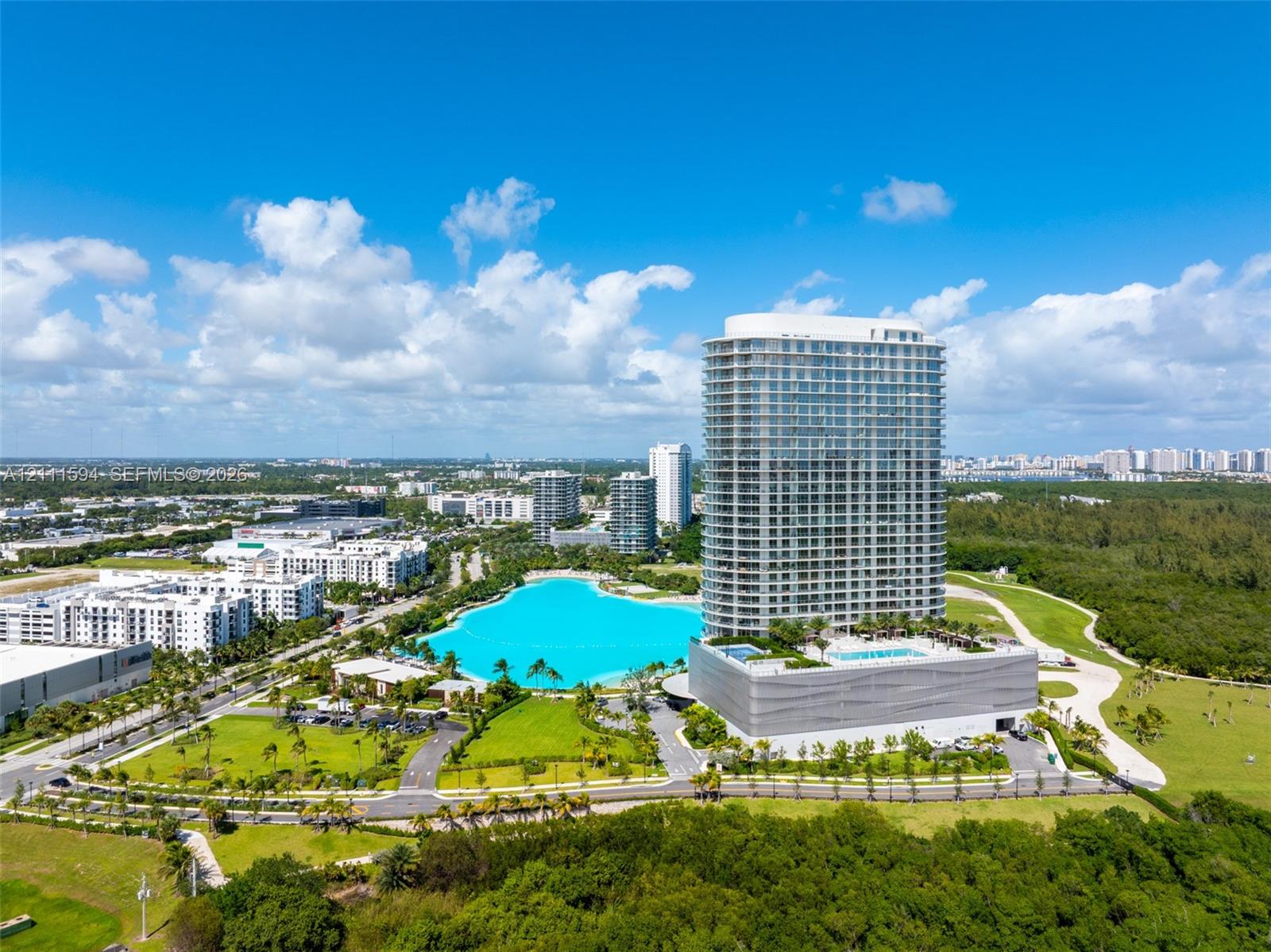 High-rise residential tower featuring a glass facade, private balconies, and a podium-level swimming pool