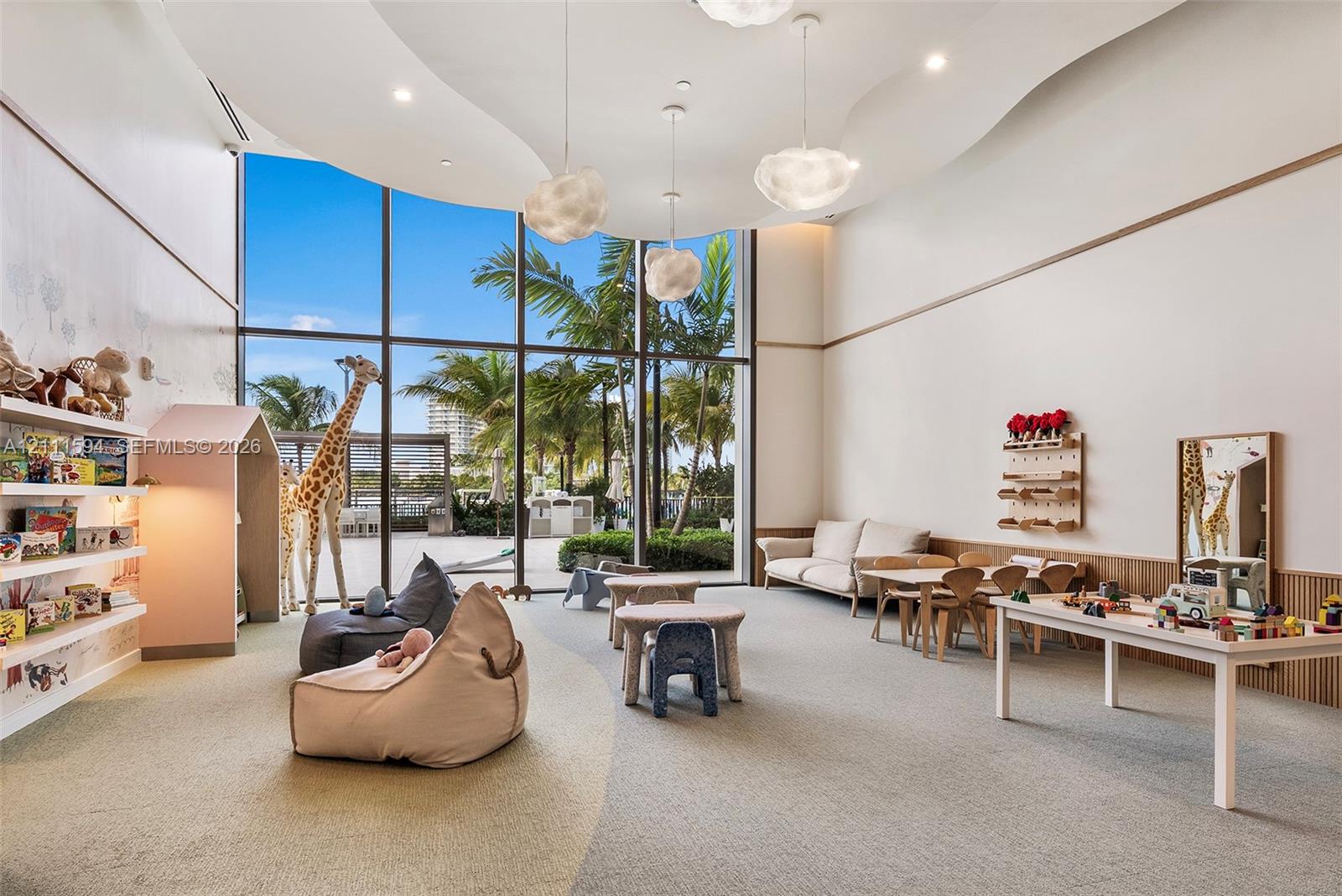 Floor-to-ceiling windows, custom sculpted ceiling with recessed lighting, integrated wall shelving, wood-paneled wainscoting, and suspended contemporary light fixtures