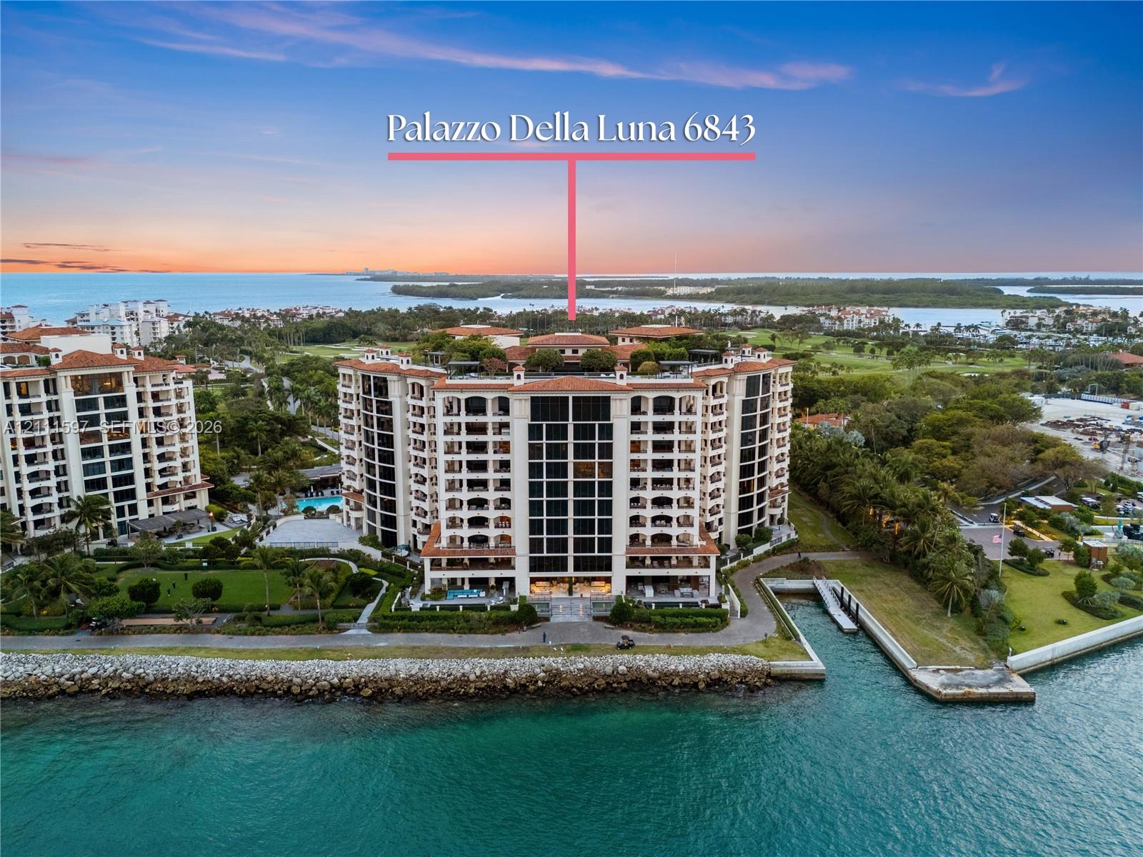 Waterfront mid-rise building featuring clay tile roofing, multiple private balconies, a ground-level swimming pool, and direct bulkhead access to the water