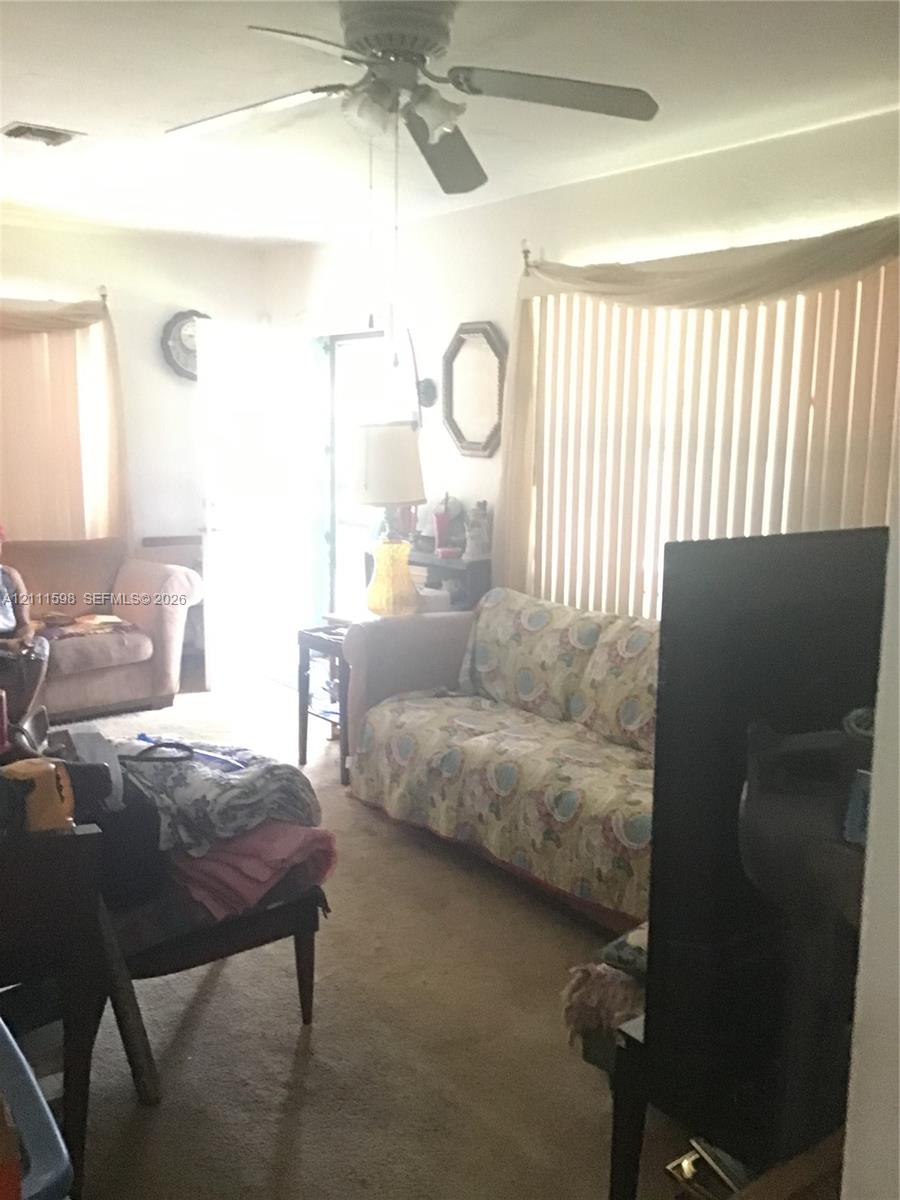 Ceiling-mounted fan with integrated light fixture and vertical window blinds