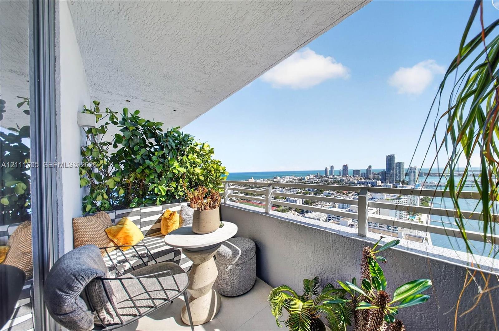 Private covered balcony featuring neutral tile flooring, a textured concrete ceiling, and a metallic horizontal-bar railing